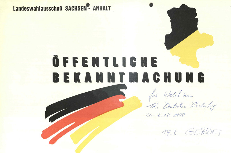 Druck mit der Aufschrift Öffentliche Bekanntmachung, links unten drei Farbstreifen in schwarz, rot, gold, oben rechts oben Umrisse Sachsen-Anhalts in schwarz-gold, darunter eine handschriftliche Notiz
